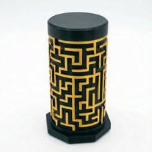 Load image into Gallery viewer, A dark black cylindrical puzzle box with a gold maze pattern on the side, standing on a matching dark black octagonal base against a white background.